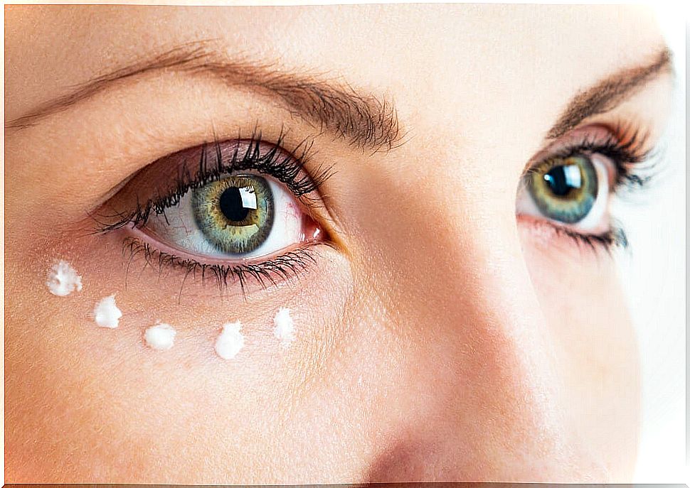 Woman using vitamin capsule as eye cream