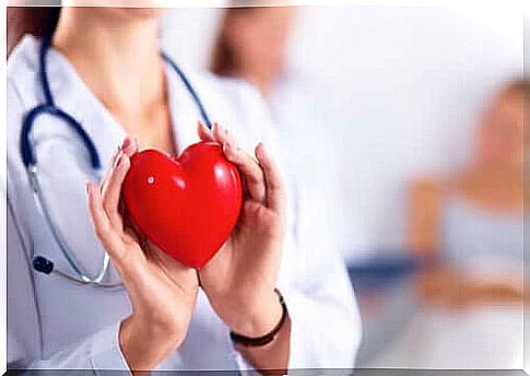 Female doctor holding heart.