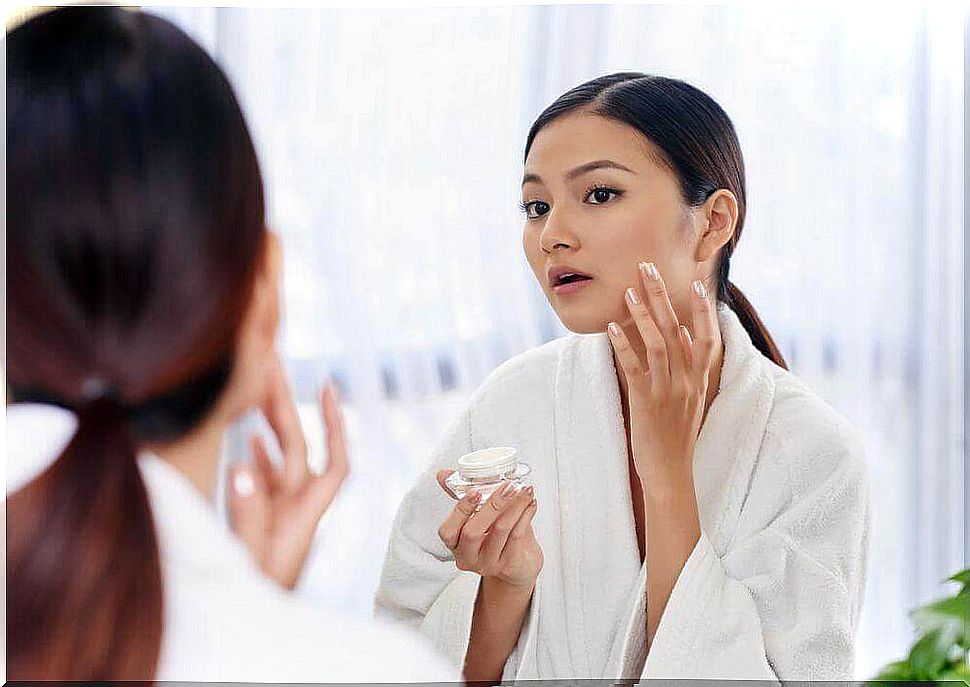 Woman applying a sunscreen treatment cream.